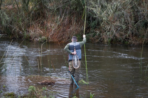 Fisherman fly fishing rainbow trout on mountain in beautiful scenery