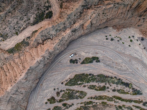 Aerial view, 4x4 car, Camping in dry riverbed, View from above, Canyon runs through landscape, Dramatic barren landscape of eroded hills, Badlands, Canyon of the Forgotten Rivers, Issyk Kul, Kyrgyzstan, Asia