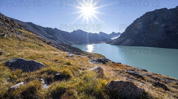 Mountain landscape at the turquoise Ala Kul mountain lake in the morning light, Sun Star, Tien Shan Mountains, Kyrgyzstan, Asia
