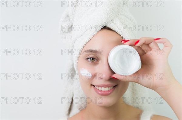 Skincare, product and woman with cream on face, and excited advertising luxury skin care promotion. Dermatology, spa cosmetics and facial for happy model girl isolated on studio background