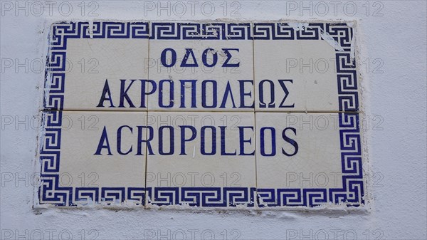 Tiles on a wall with the inscription 'AKROPOLIS' in blue letters, Lindos, Rhodes, Dodecanese, Greek Islands, Greece, Europe