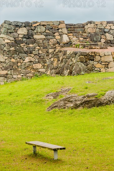 Remains of Japanese stone fortress with park bench in foreground in Suncheon, South Korea, Asia