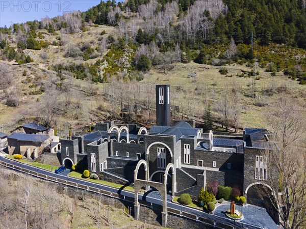 Aerial view of an abbey with dark tiled roofs in the midst of a mountainous landscape in spring, Santuario de Meritxell monastery, Sanctuary of Our Lady of Meritxell, Meritxell, Canillo, Andorra, Pyrenees, Europe