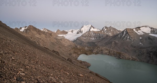Turquoise mountain lake Ala Kul Lake, mountain peaks with glaciers at dusk, Ala Kul Pass, Tien Shan Mountains, Kyrgyzstan, Asia