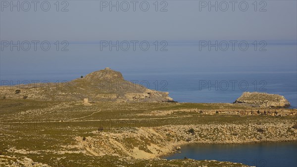 Tranquil coastal landscape with a lighthouse on a hill, Lindos, Rhodes, Dodecanese, Greek Islands, Greece, Europe