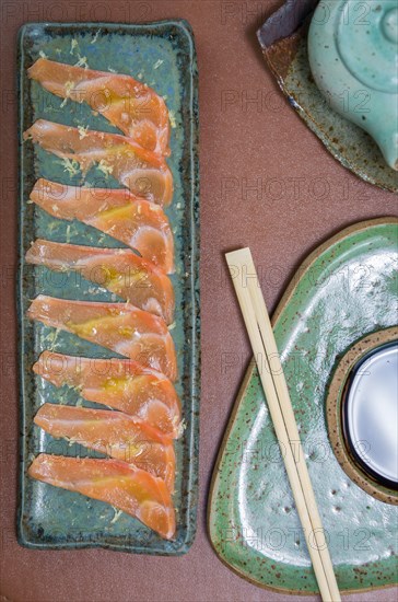 Delicious premium salmon sashimi arranged on an elegant handmade platter