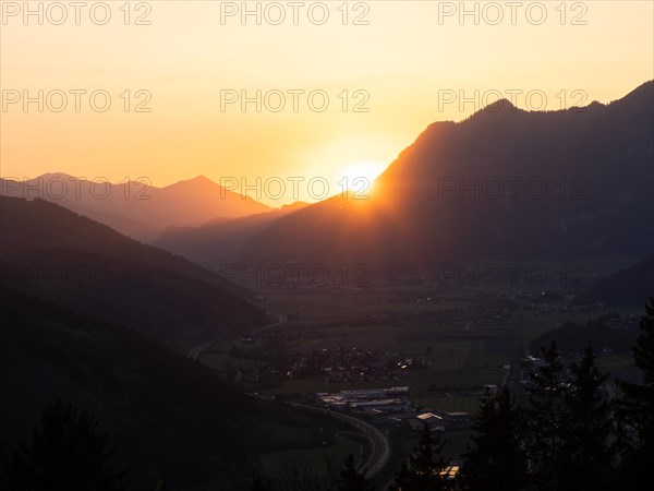 Sunset over mountain peak, in the valley the village Traboch, Schoberpass federal road, view from the lowland, Leoben, Styria, Austria, Europe