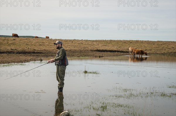 Sport fisherman fishing in lake on cloudy day, Cambara do sul, Rio Grande do sul, Brazil, South America