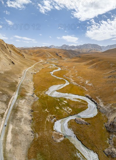 Aerial view, Kol Suu River winds through a mountain valley with hills of yellow grass, Naryn Province, Kyrgyzstan, Asia