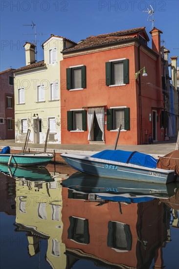 Moored boats on canal lined with red and yellow stucco houses, Burano Island, Venetian Lagoon, Venice, Veneto, Italy, Europe