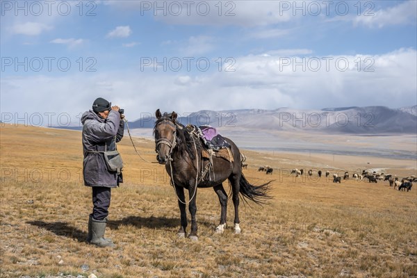 Nomadic life on a plateau, shepherd on horse, flock of sheep, dramatic high mountains, Tian Shan Mountains, Jety Oguz, Kyrgyzstan, Asia