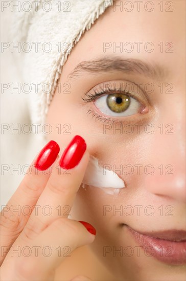 Hydration. Cream smear. Beuaty close up portrait of young woman with a healthy glowing skin is applying a skincare product