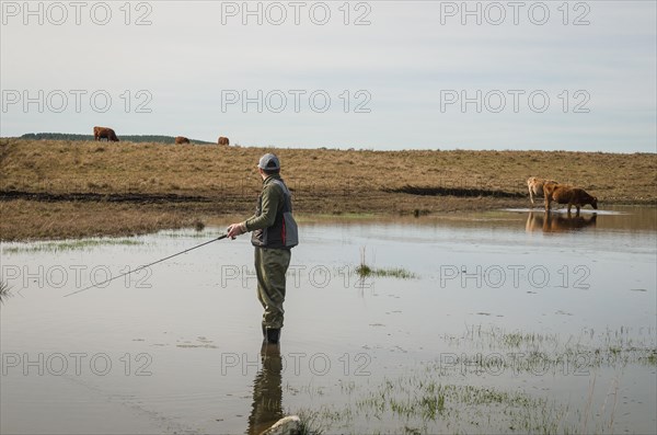 Sport fisherman fishing in lake on cloudy day, Cambara do sul, Rio Grande do sul, Brazil, South America