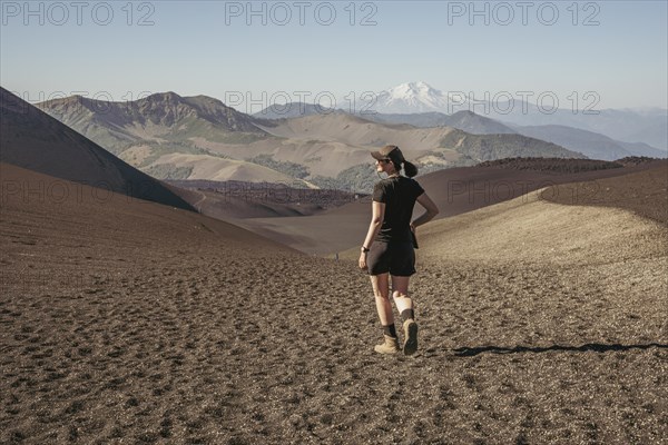 Young woman walking through lava fields, Crater Navidad, Lonquimay volcano, Malalcahuello National Reserve, Curacautin, Araucania, Chile, South America