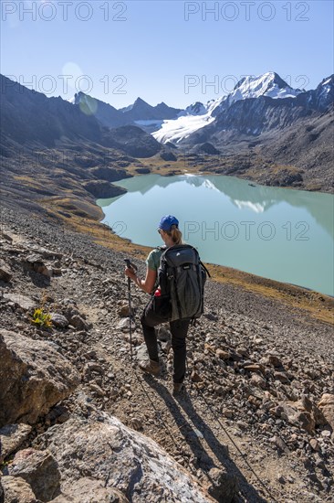 Trekking, hiker in the Tien Shan high mountains, mountain lake Ala-Kul Lake, 4000 metre peak with glacier, Ak-Su, Kyrgyzstan, Asia