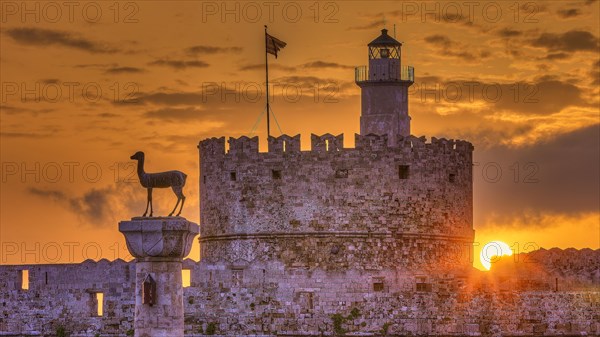 An old castle with a statue in honour of a sunrise under bright clouds, Sunrise, Dawn, Fort of Saint Nikolaos, European roe deer statue, Harbour promenade, Rhodes, Dodecanese, Greek Islands, Greece, Europe