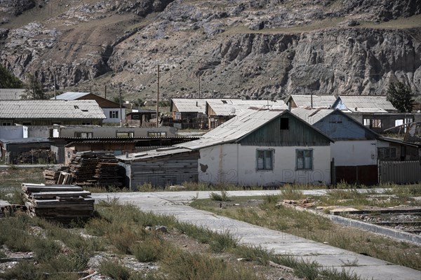 Abandoned buildings in a barren landscape, ghost town of Enilchek in the Tien Shan Mountains, Ak-Su, Kyrgyzstan, Asia