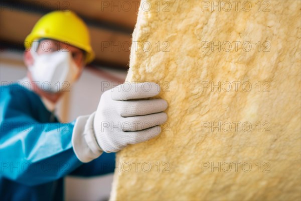 Construction worker installing mineral wool filling used as isolation material in walls. KI generiert, generiert, AI generated