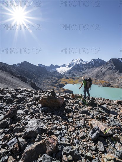 Mountaineers on the way to the Ala Kul Pass, view of mountains and glaciers and turquoise Ala Kul mountain lake, Sun Star, Tien Shan Mountains, Kyrgyzstan, Asia