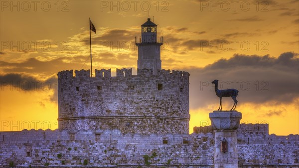 The ancient structure of a castle with a lighthouse during a picturesque sunrise, sunrise, dawn, European roe deer statue, Fort of Saint Nikolaos, harbour promenade, Rhodes, Dodecanese, Greek Islands, Greece, Europe