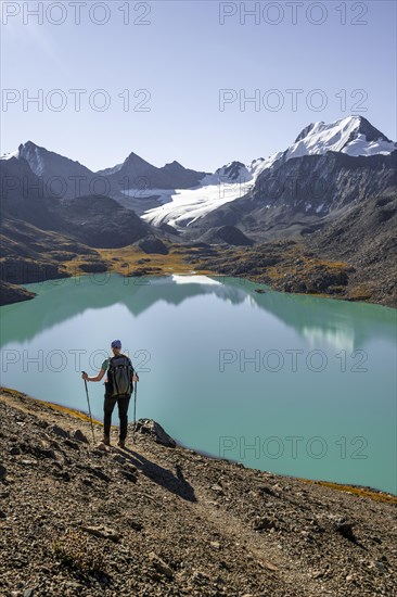 Trekking, hiker in the Tien Shan high mountains, mountain lake Ala-Kul Lake, 4000 metre peak with glacier, Ak-Su, Kyrgyzstan, Asia