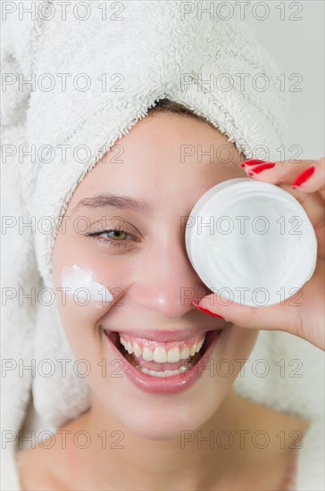 Skincare, product and woman with cream on face, and excited advertising luxury skin care promotion. Dermatology, spa cosmetics and facial for happy model girl isolated on studio background