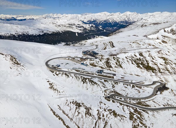 Mountain road winds through a wintry landscape in daylight, serpentine road near El Pas de la Casa, Encamp, Andorra, Pyrenees, Europe