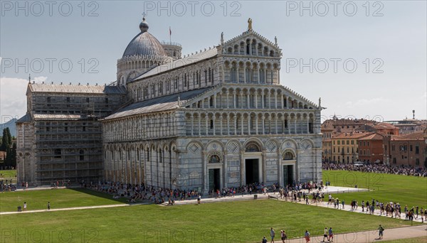 Historic cathedral in Pisa under a clear blue sky with visitors in front of it, Pisa Italy Europe