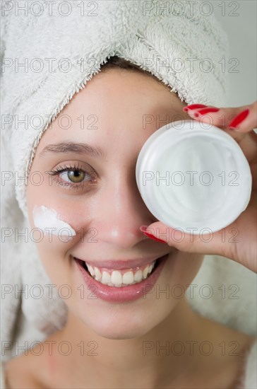 Skincare, product and woman with cream on face, and excited advertising luxury skin care promotion. Dermatology, spa cosmetics and facial for happy model girl isolated on studio background