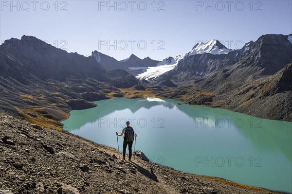 Trekking, hiker in the Tien Shan high mountains, mountain lake Ala-Kul Lake, 4000 metre peak with glacier, Ak-Su, Kyrgyzstan, Asia