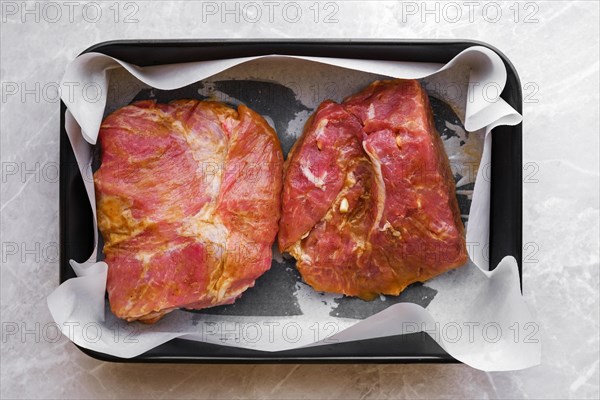 Top view of marinated in mustard and garlic pork shoulder Boston butt in a baking tray