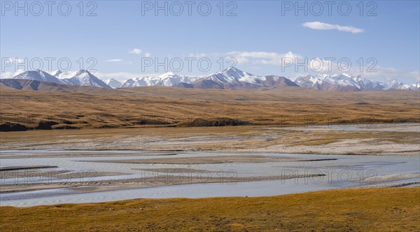 Mountain valley with meandering Sary Jaz River, high glaciated mountain peaks of the Tien Shan in the background, autumn mountains with yellow grass, Tien Shan, Kyrgyzstan, Asia