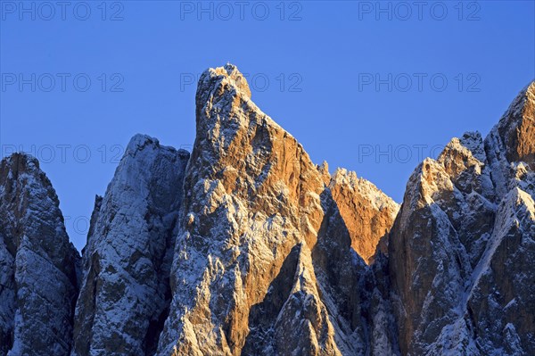 Mountain peaks illuminated by the setting sun with a clear blue sky, Italy, Trentino-Alto Adige, Alto Adige, Bolzano province, Dolomites, Santa Magdalena, St. Maddalena, Funes Valley, Odle, Puez-Geisler Nature Park in autumn, Europe