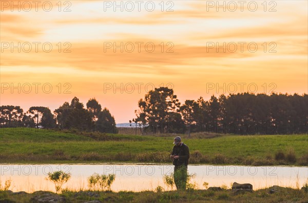 Sport fisherman fishing in lake on cloudy day, Cambara do sul, Rio Grande do sul, Brazil, South America