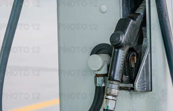 Closeup of gas pump handle with black rubberized cover inserted into side of gas pump in South Korea