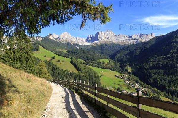 Sunlit hiking trail with a view of the mountain landscape and bright blue sky, Italy, Alto Adige, Bolzano province, Dolomites, Catinaccio/rose garden, Europe