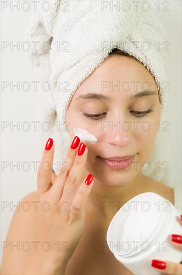 Hydration. Cream smear. Beuaty close up portrait of young woman with a healthy glowing skin is applying a skincare product