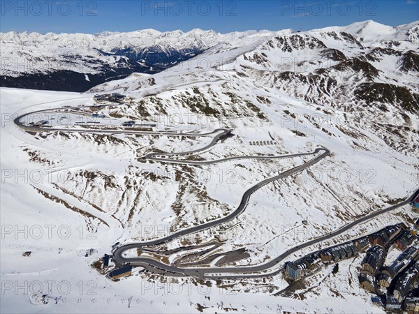 Mountain road with serpentines through a snowy mountain landscape with traffic, serpentine road near El Pas de la Casa, Encamp, Andorra, Pyrenees, Europe