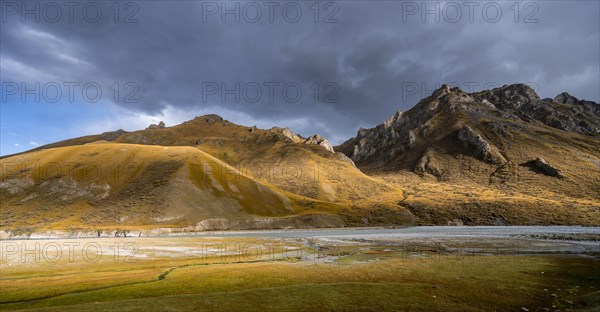 Mountain valley with Sary Jaz river in the evening light, autumn mountains with yellow grass, Tien Shan, Kyrgyzstan, Asia