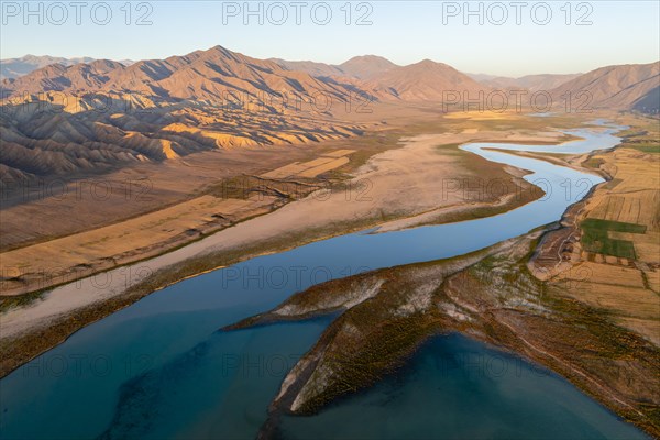 Naryn River between mountains and fields, at Toktogul Reservoir at sunset, aerial view, Kyrgyzstan, Asia