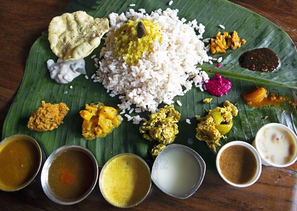 Sadya or variety of traditional vegetarian dishes served for lunch on a banana leaf, Kerala, India, Asia