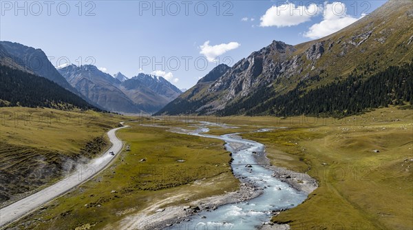 Car on road, mountain river in green mountain valley in the Tien Shan Mountains, Jety Oguz, Kyrgyzstan, Asia