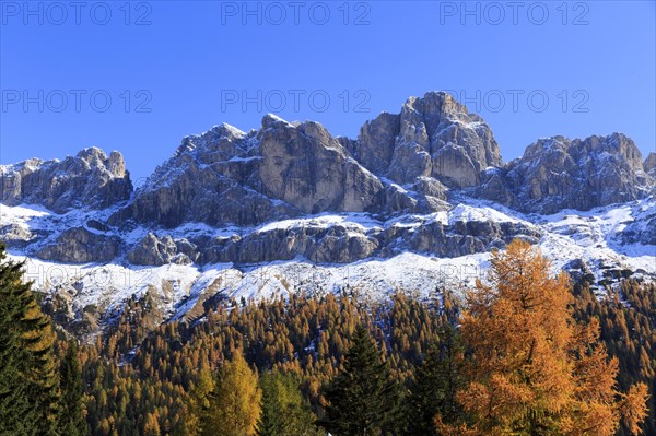 An impressive snow-covered mountain range above autumnal forests and rocks, Italy, Trentino-Alto Adige, Alto Adige, Bolzano province, Dolomites, Santa Magdalena, St. Maddalena, Funes Valley, Odle, Puez-Geisler Nature Park in autumn, Europe