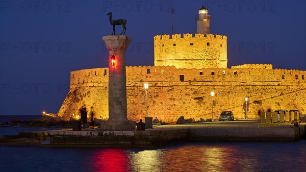 Night view of an old fortress with red lights and a sculpture by the sea, night shot, deer statue, Fort Agios Nikolaos, Mandraki harbour, European roe deer, Rhodes, Dodecanese, Greek Islands, Greece, Europe