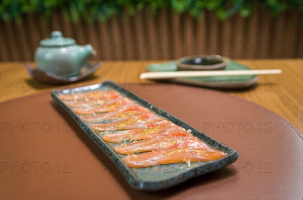 Delicious premium salmon sashimi arranged on an elegant handmade platter