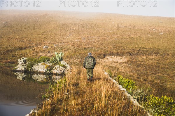Sport fisherman fishing in lake on cloudy day, Cambara do sul, Rio Grande do sul, Brazil, South America