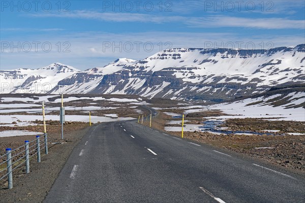 Road leads through barren mountain landscape with snow and ice, Seydisfjoerdur, Fjaroarheioi, Iceland, Europe
