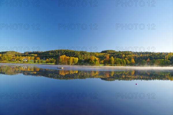 Autumn morning mist over a calm lake, foliage colouring, Bullaren, Bohuslaen. Sweden