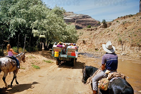 Tourists and horse riders in Canyon de Chelly National Monument, an area of the Navajo Nation in the north-east of the US state of Arizona. The nearest town is Chinle. Colorado Plateau, Arizona, USA, North America