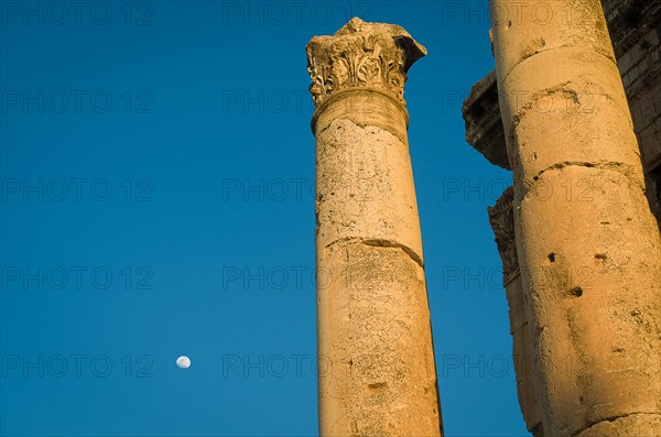 Ruins of Baalbek. Ancient city of Phenicia, located in the Beca valley, Lebanon. Acropolis with Roman remains. Roman tower being restored, moon in the sky